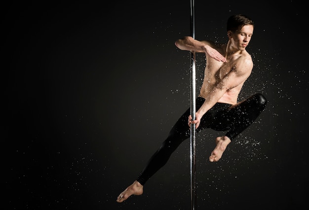 Free photo portrait of professional male model performing a pole dance