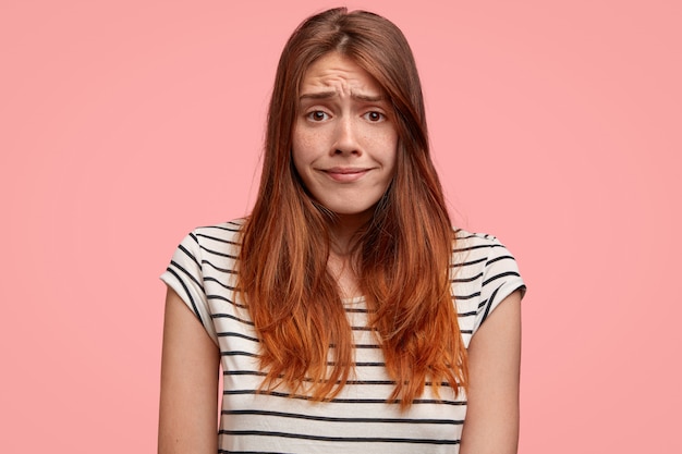 Free photo portrait of puzzled female frowns face with dissatisfaction, has sorrowful expression, feels embarrassed. people, facial expressions