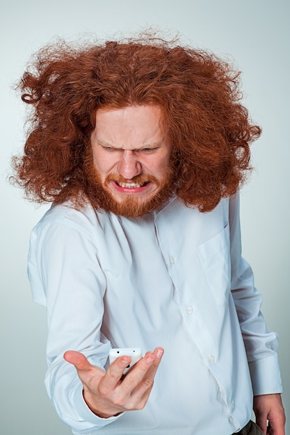 Free photo portrait of puzzled man talking on the phone  a gray background