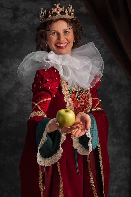 Free photo portrait of queen with crown and apple fruit