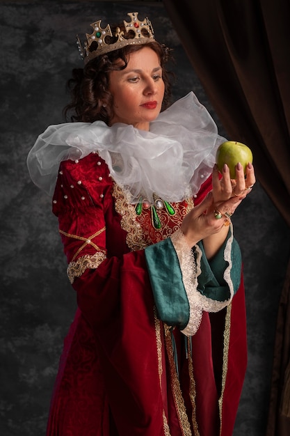 Portrait of queen with crown and apple fruit