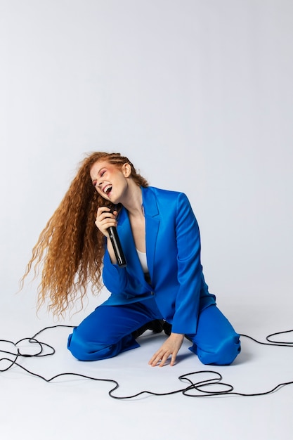 Free photo portrait of redhaired singing woman with micorphone