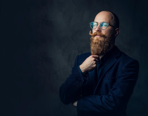 Free Photo portrait of redhead bearded male in eyeglasses dressed in an elegant wool suit over grey background.