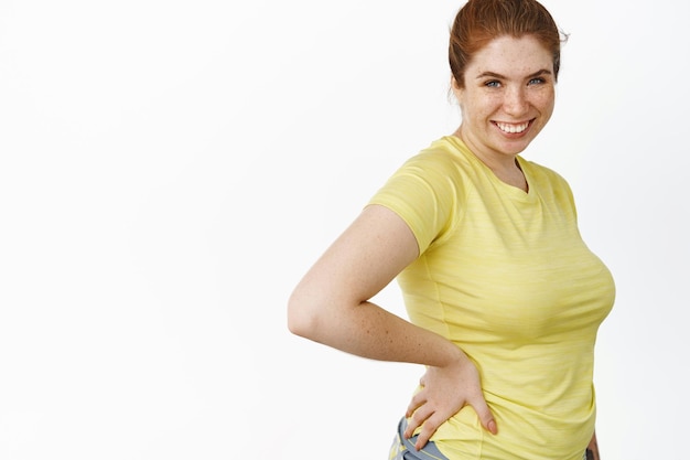 Free photo portrait of redhead plus size woman in sport outfit workout in gym doing fitness exercise white background