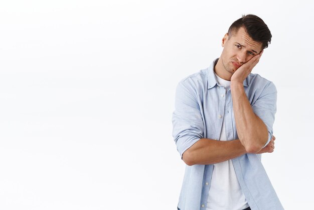 Portrait of reluctant and tired caucasian guy lean on palm and grimacing waiting for girlfriend dressup standing moody and distressed feel sad over sitting selfquarantine lockdown at home