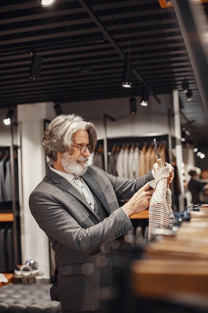 Free Photo portrait of a rich mature man. senior visiting a fashion boutique. male buy a new exclusive costume.