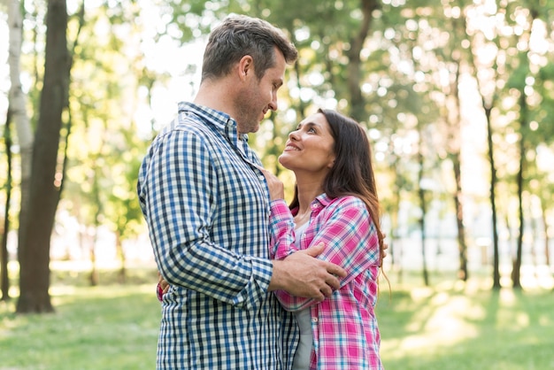 Portrait of romantic couple looking at each other while embracing in park