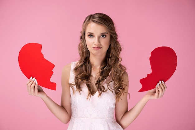 Free photo portrait of sad woman holding broken heart