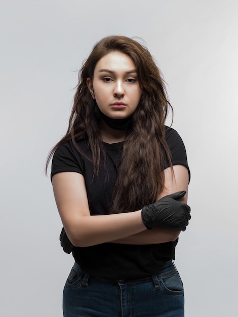 Portrait of sad young woman with crossed hands and black gloves