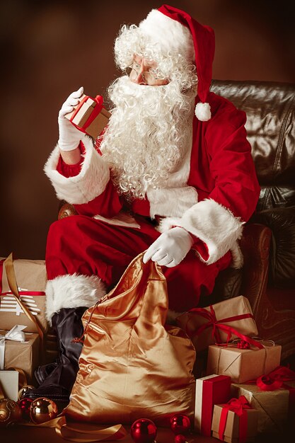 Portrait of Santa Claus in red costume with gift box