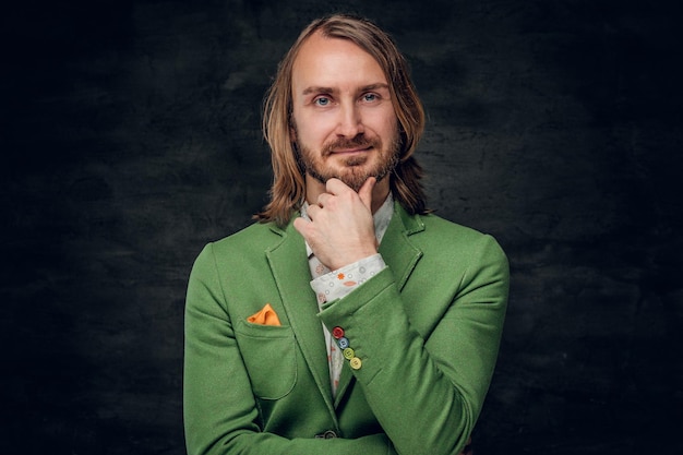 Free photo portrait of sceptical creative man in green blazer on the dark background.