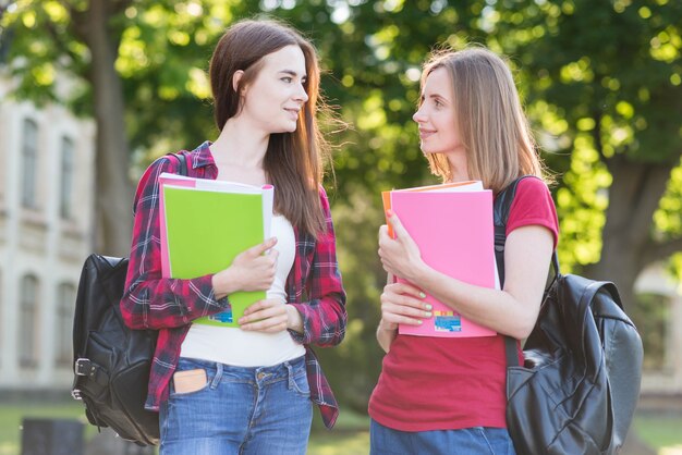 Portrait of school girls with books in park