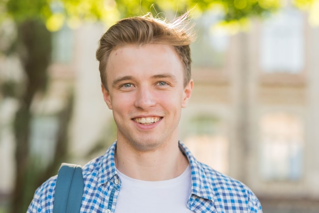 Portrait of schoolboy in front of school building