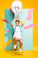 Free photo portrait of schoolgirl with big light bulb