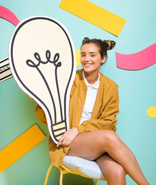 Portrait of schoolgirl with big light bulb