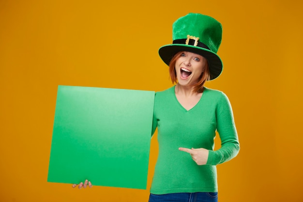 Portrait of screaming leprechaun pointing at banner