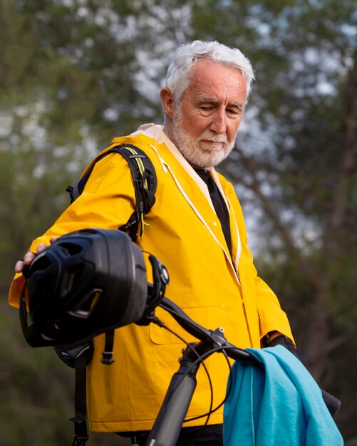 Portrait senior man with bike on mountain