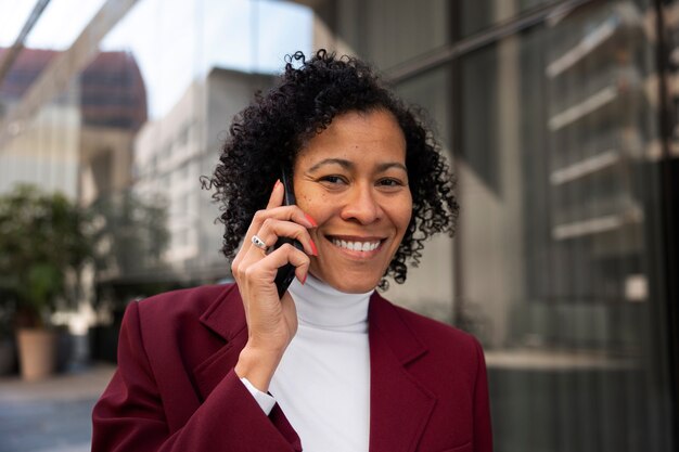 Portrait of senior woman in professional blazer outdoors and smartphone