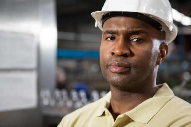 Free Photo portrait of serious male employee wearing hard hat in factory