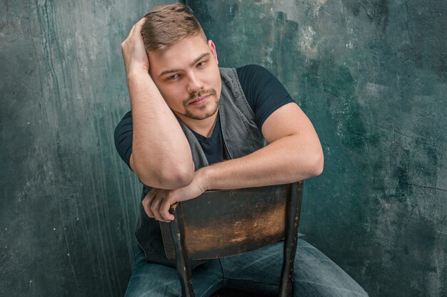 Portrait of serious man sitting on the chair in studio