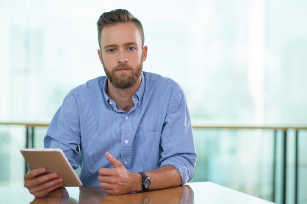 Portrait of serious manager with digital tablet