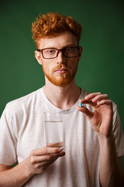 Portrait of a serious young redhead man in eyeglasses