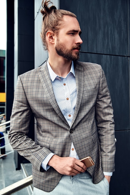 Portrait of sexy handsome man dressed in elegant beige checkered suit