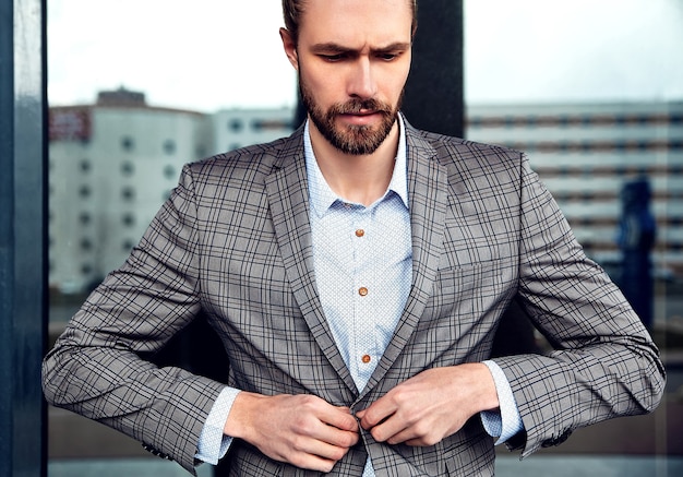 Free photo portrait of sexy handsome man dressed in elegant beige checkered suit