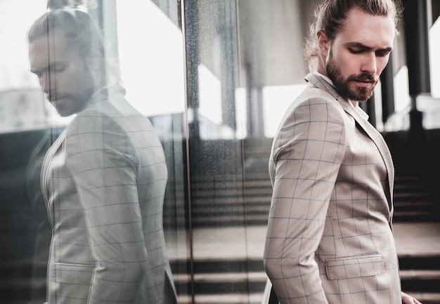 Free photo portrait of sexy handsome man dressed in elegant beige checkered suit