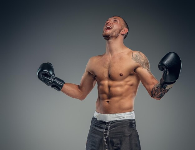 Portrait of shaved head fighter with tattoos on his body.