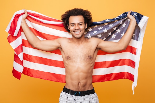 Free photo portrait of a shirtless afro american man holding usa flag