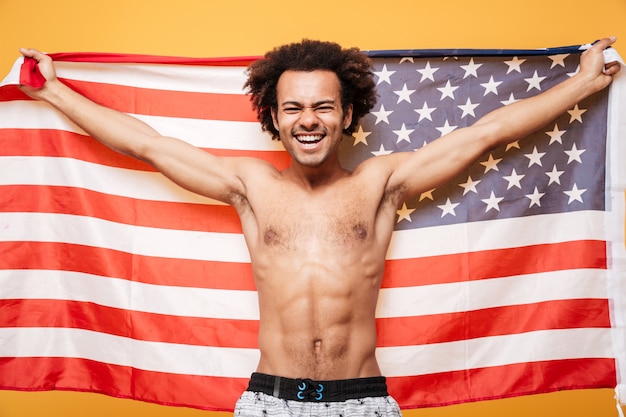 Free photo portrait of a shirtless afro american man holding usa flag