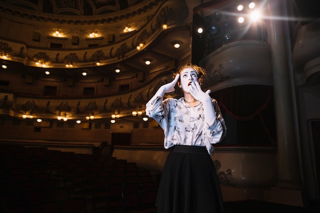 Free Photo portrait of shocked female mime standing in auditorium looking up