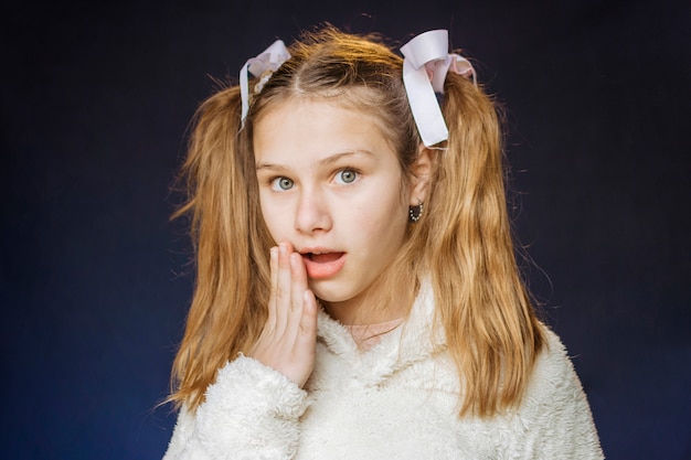 Free photo portrait of a shocked girl on black background