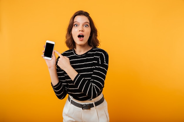 Portrait of a shocked girl pointing finger