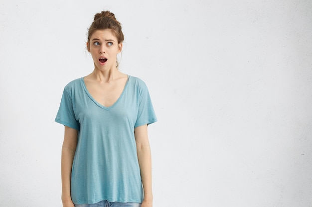 portrait of shocked young female wearing blue shirt, having beautiful appearance