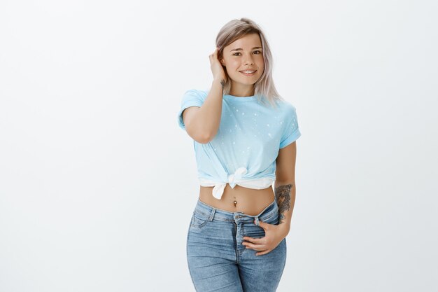 Portrait of shy blonde girl posing in the studio