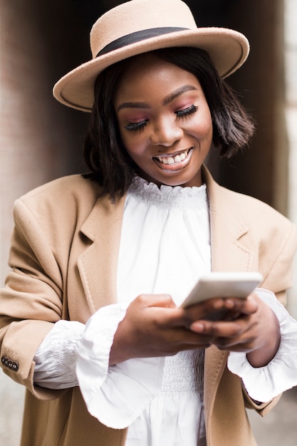 Portrait of smiley fashionable woman looking on her phone