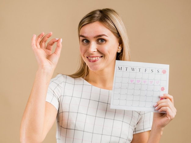 Portrait of  smiley female holding menstruation calendar