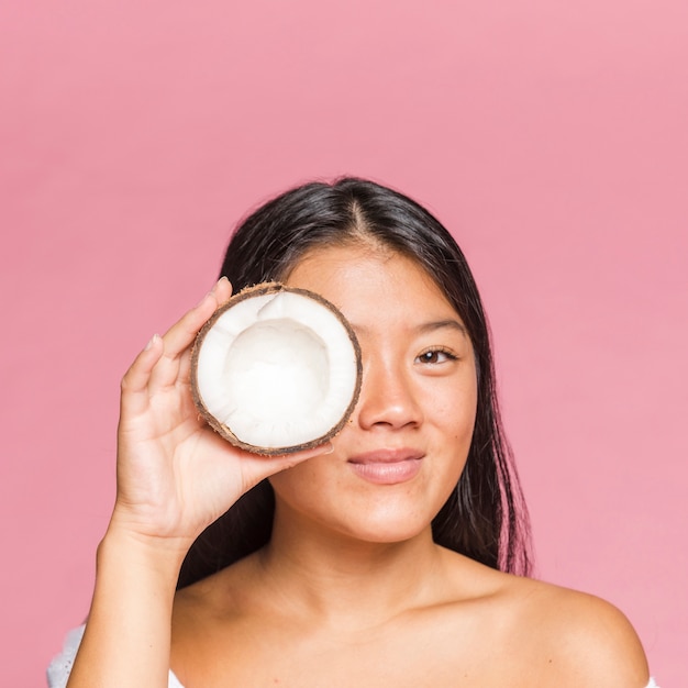 Portrait of smiley woman holding a coconut