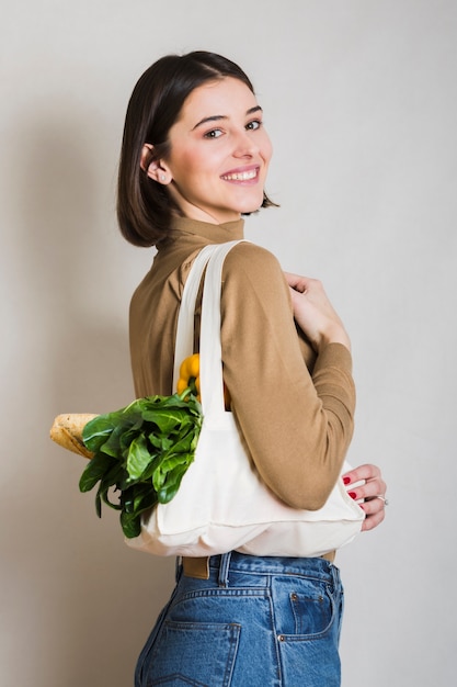 Free photo portrait of smiley woman holding ecological groceries