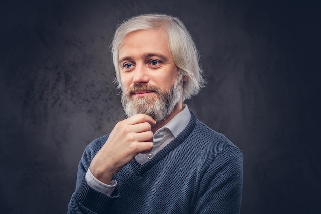 Free photo portrait of smiling aged male with a gray beard isolated on a dark background.