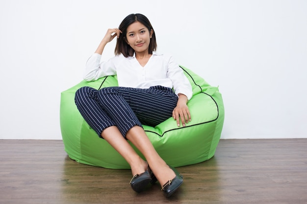 Free photo portrait of smiling asian executive on beanbag