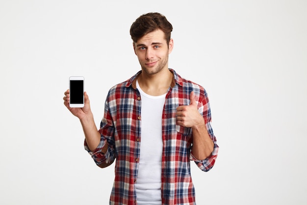 Free photo portrait of a smiling attractive man holding blank mobile phone