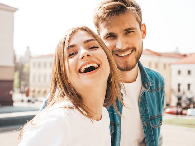 Portrait of smiling beautiful girl and her handsome boyfriend in casual summer clothes.  . Hugging