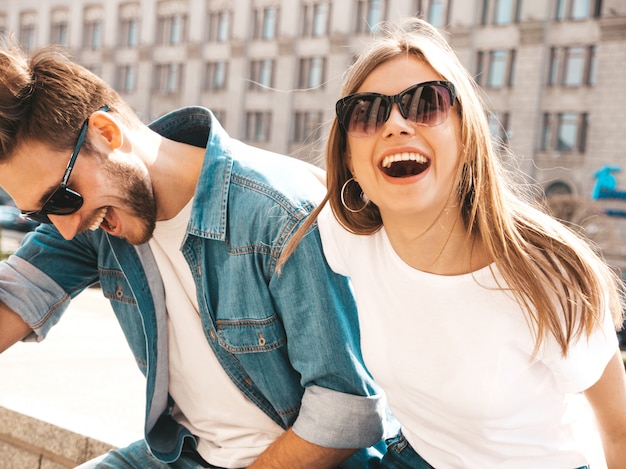 Free Photo portrait of smiling beautiful girl and her handsome boyfriend in casual summer clothes and sunglasses.  . hugging