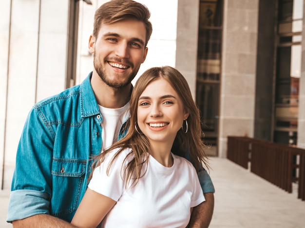 Portrait of smiling beautiful girl and her handsome boyfriend. Woman in casual summer jeans clothes.  . Hugging