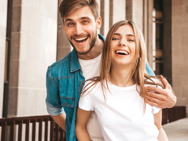 Portrait of smiling beautiful girl and her handsome boyfriend. Woman in casual summer jeans clothes.  . Hugging