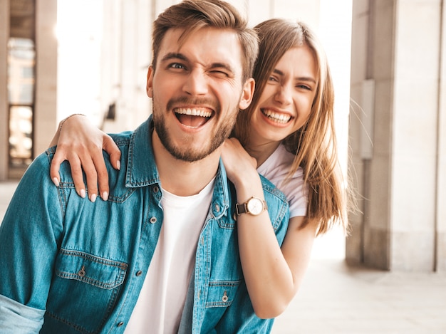 Free photo portrait of smiling beautiful girl and her handsome boyfriend. woman in casual summer jeans clothes.  . winking