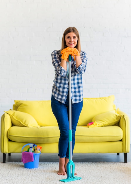 Portrait of smiling beautiful young woman with cleaning equipments